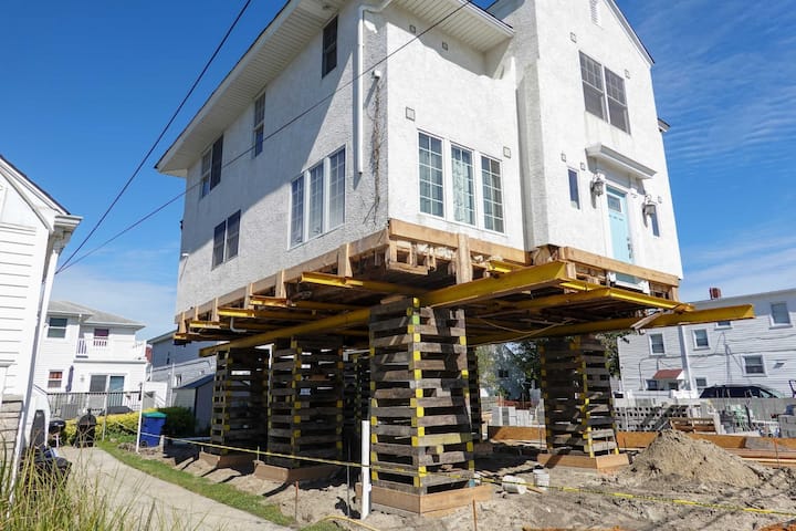 A team of professionals using specialized equipment to raise a house in Harrisburg, preparing it for elevation and renovation